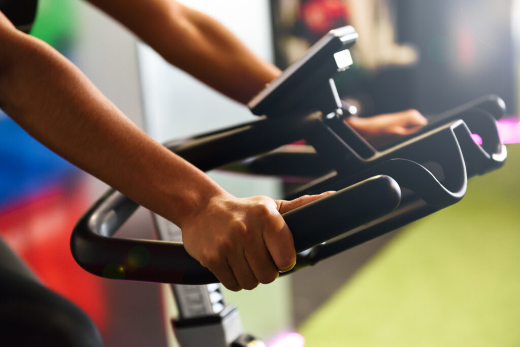 woman gym doing spinning cyclo indoor with smart watch